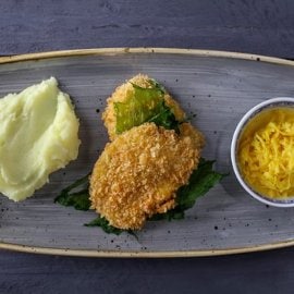 Шніцель зі свинини з картопляним пюре, тушкованою капустою і карі